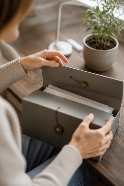Personne rangeant des documents dans une chemise fermée, sans nom, chiffre ni donnée personnelle visible